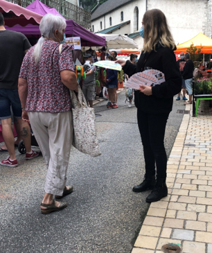 Une jeune femme distribue des tracts dans la rue pour le compte de Gaston Diffusion, spécialiste du Street Marketing.