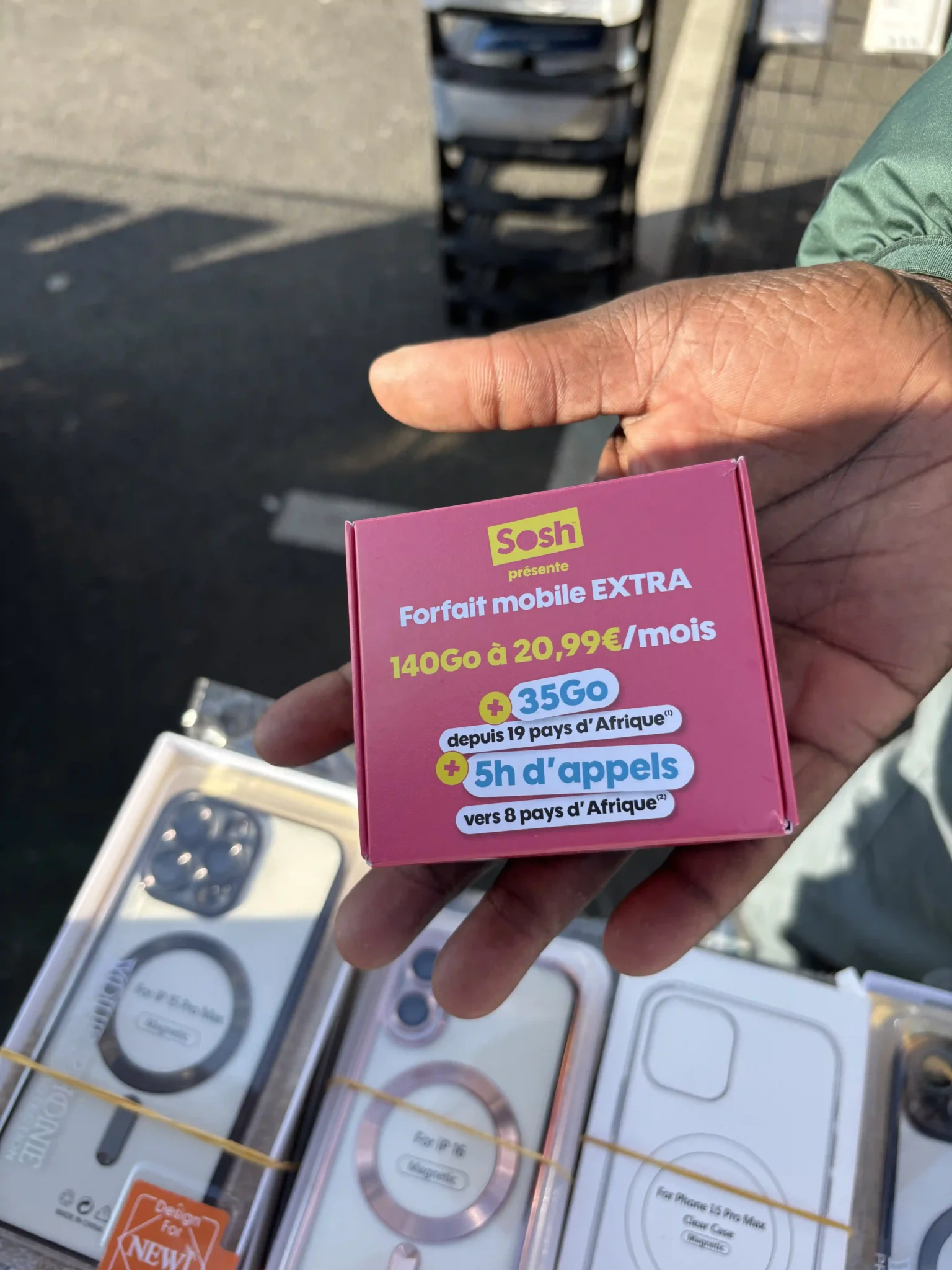 Main tenant un kit promotionnel mobile personnalisé destiné à la distribution sur le terrain.