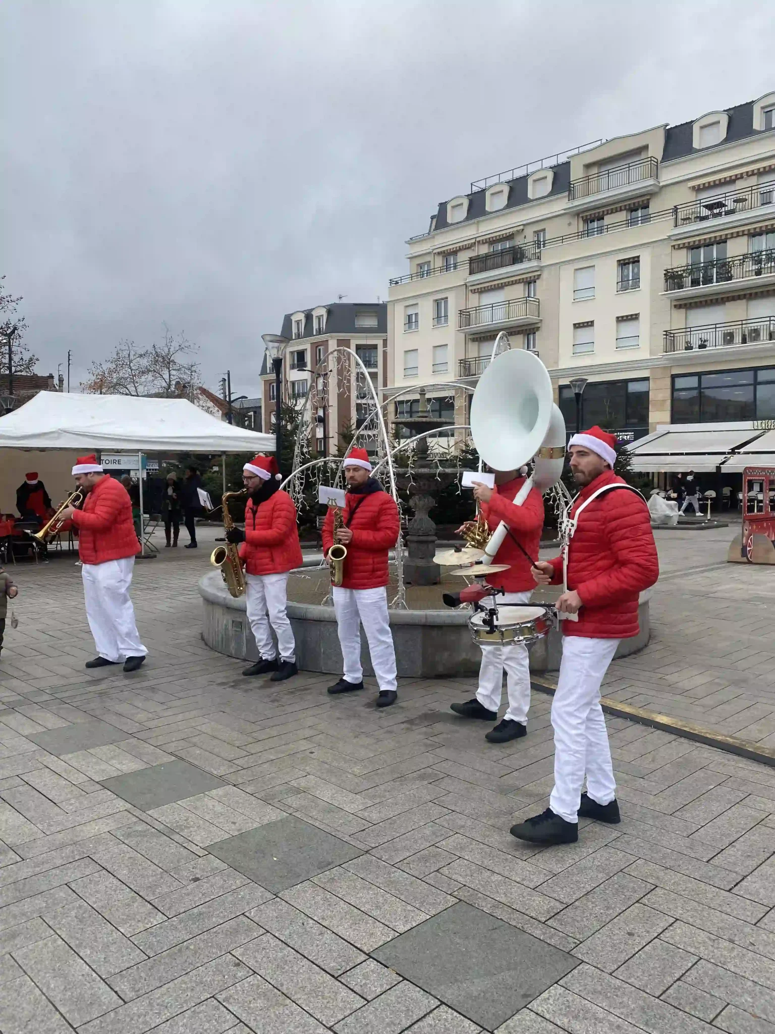 Groupe de musiciens en fanfare de Noël jouant en plein air.